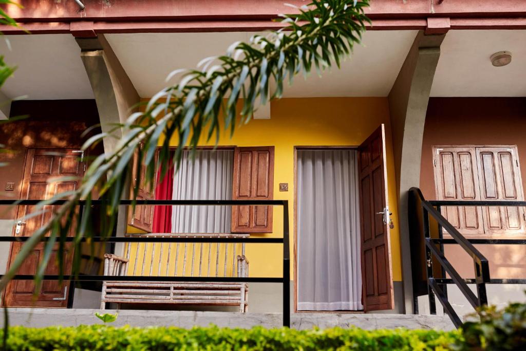 a balcony of a house with doors and a fence at Andasibe Lemurs Lodge in Andasibe