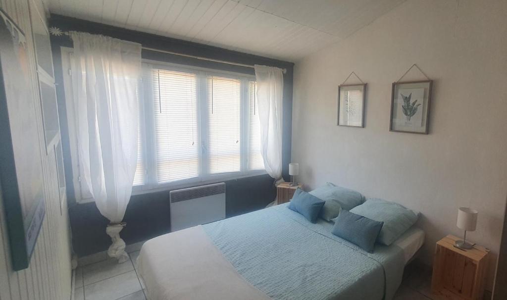 une chambre avec un lit et une grande fenêtre dans l'établissement Studio indépendant 27m2 Sanary sur Mer, à Sanary-sur-Mer