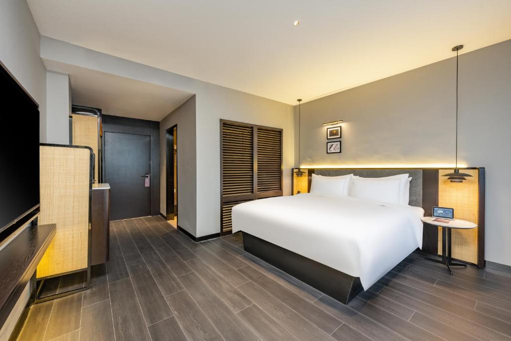 Postel nebo postele na pokoji v ubytování UrCove by HYATT Shanghai Jinqiao Centre