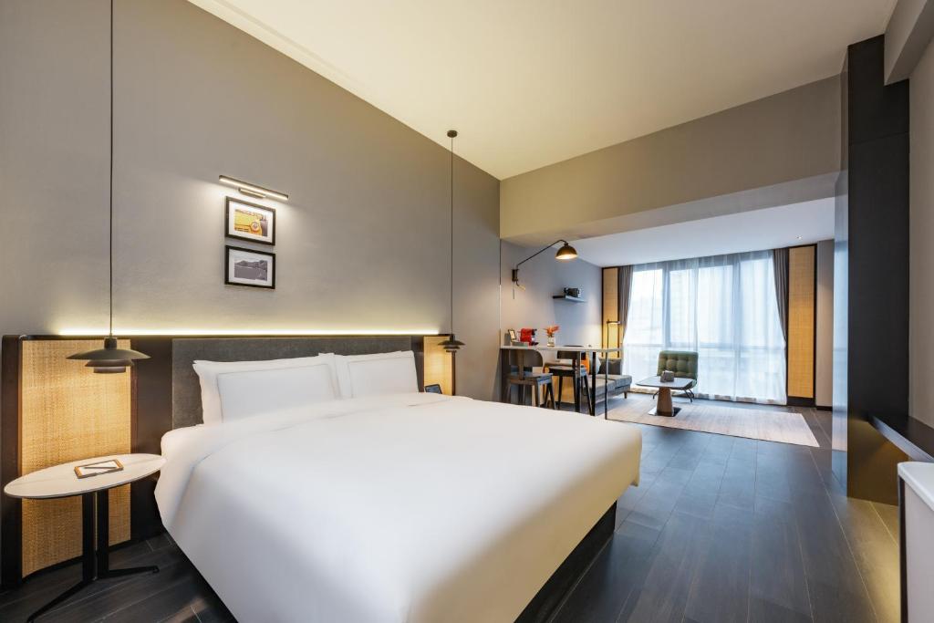 Postel nebo postele na pokoji v ubytování UrCove by HYATT Shanghai Jinqiao Centre