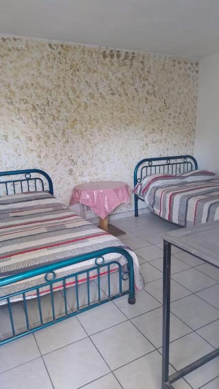a room with two beds and a table at Cuarto independiente doble in Culiacán