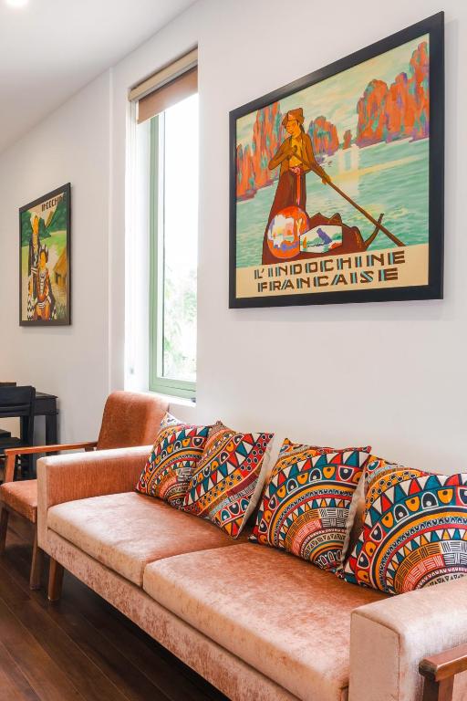 a couch in a living room with a poster at Indochine apartment in An Bàn (2)