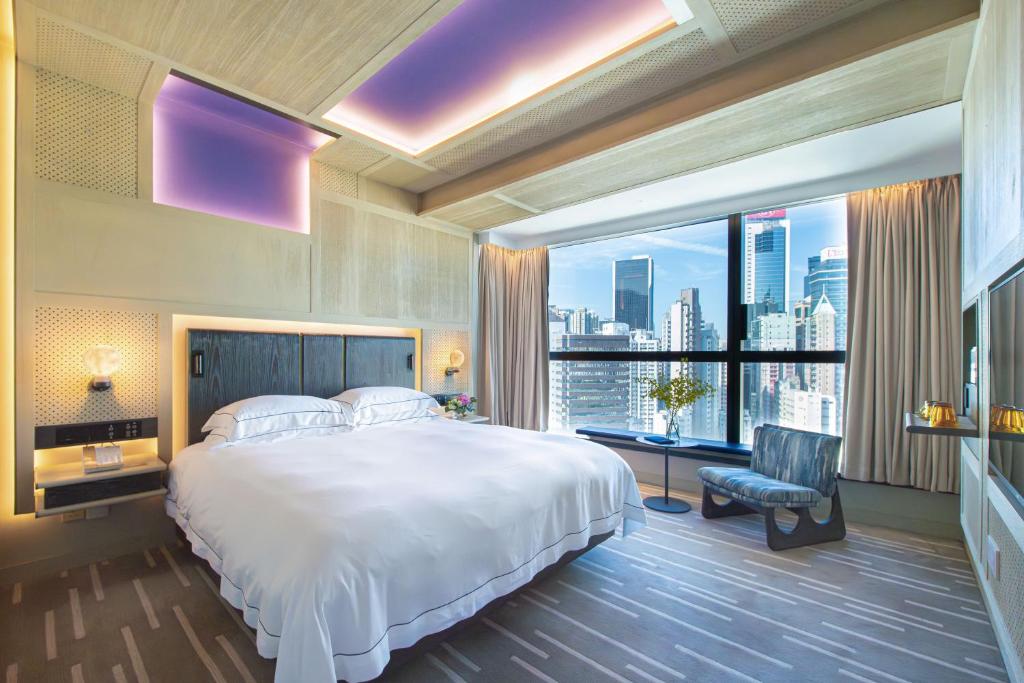 una camera con un grande letto e una grande finestra di The Emperor Hotel a Hong Kong