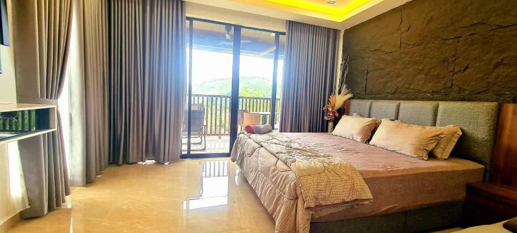 a bedroom with a bed in a room with a balcony at CBHResort Agrofarm in Kampong Benchah Tualang