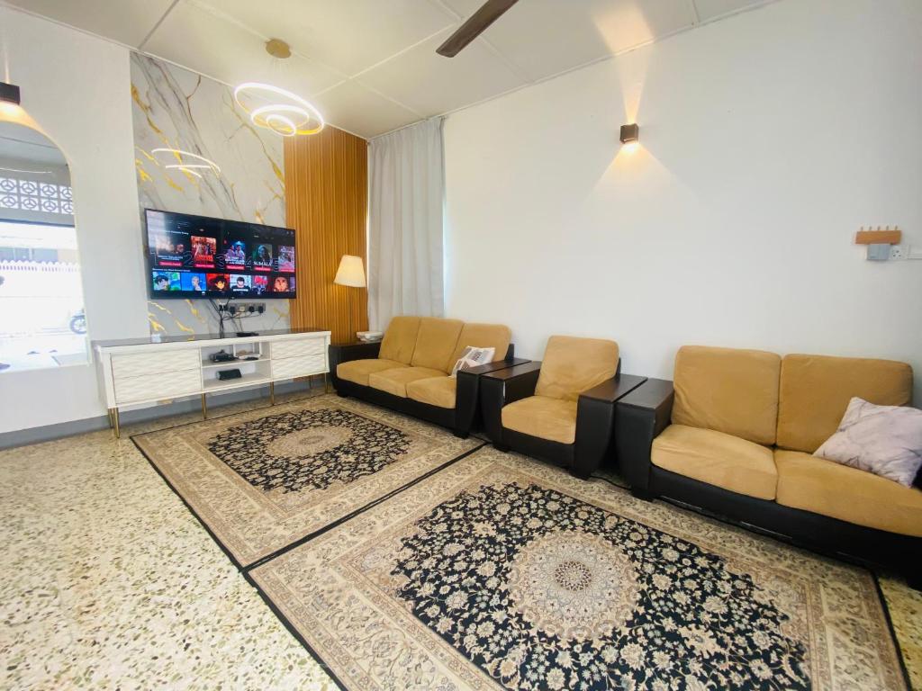 a living room with two couches and a flat screen tv at MARIDA HOMESTAY 2 moslim in Seremban