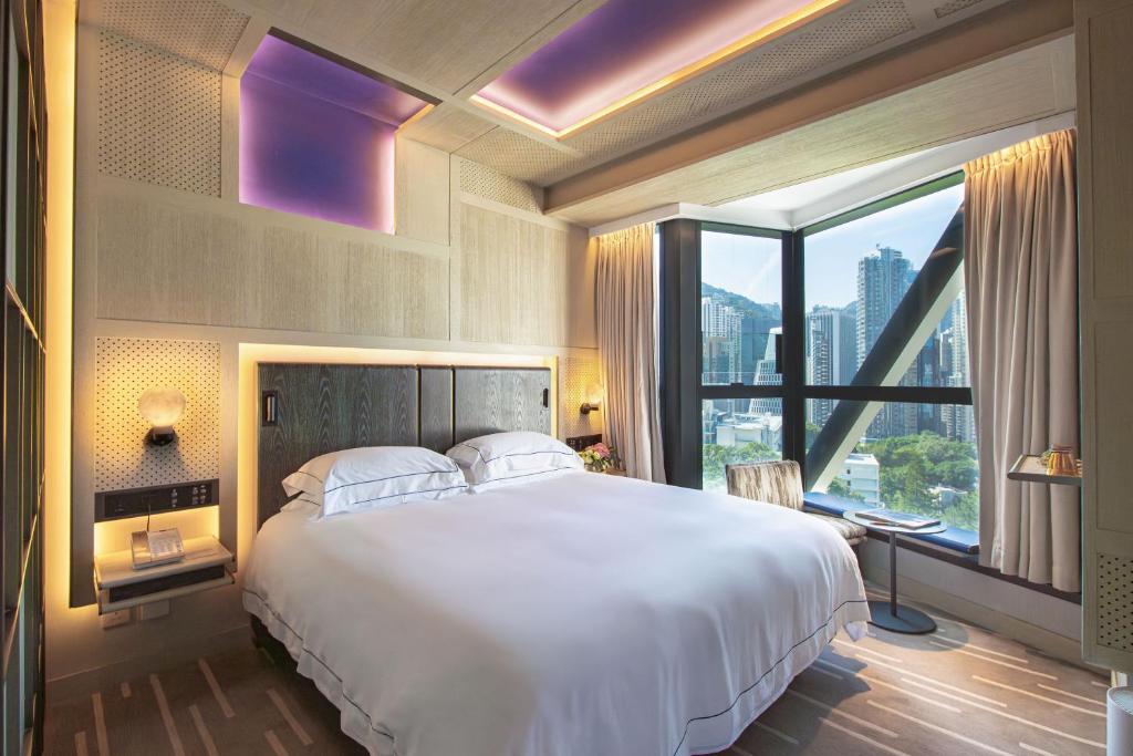 una camera con un grande letto e una grande finestra di The Emperor Hotel a Hong Kong