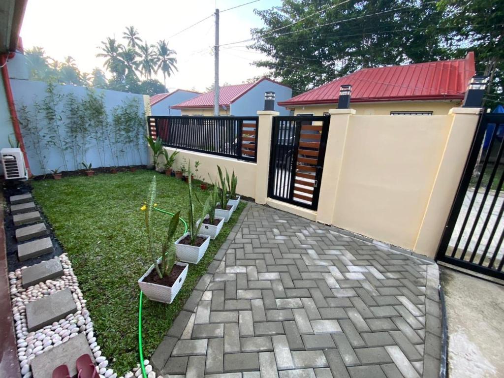 a backyard with a fence and some plants at Kendras Happy Place Butuan in Butuan
