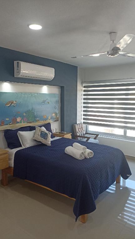 una camera blu con un grande letto con asciugamani di Bungalow 5 Vista Tropical a San Patricio Melaque