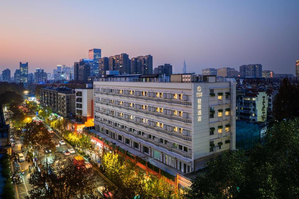 南京南京博物院瑞金路轻居酒店的夜晚城市中的一座白色大楼