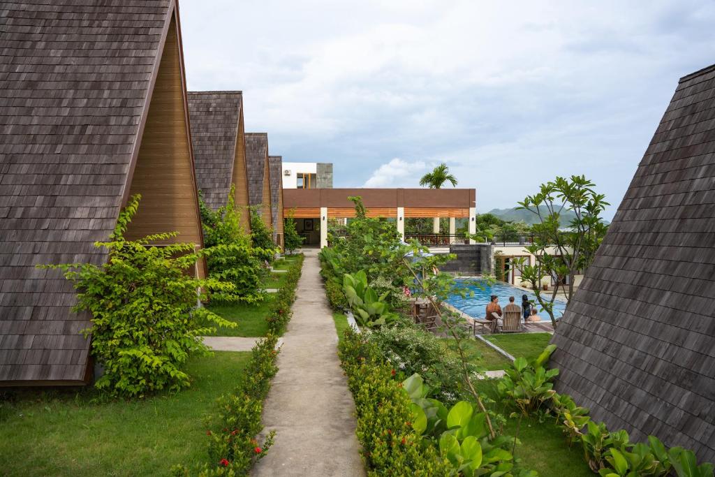 a walkway between two buildings with a pool at Maya Ocean Resort in Selong Belanak