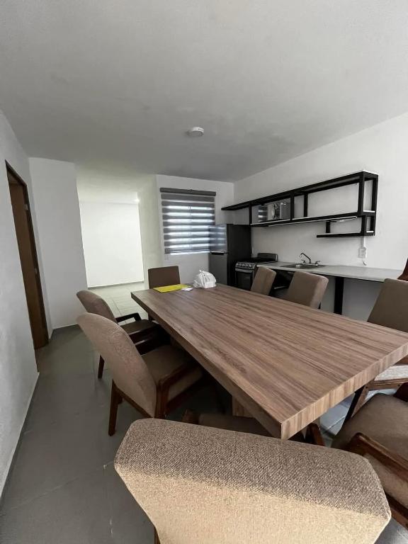 a dining room with a wooden table and chairs at Departamento San Cristóbal in Mexico City