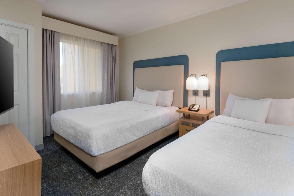 a hotel room with two beds and a television at Homewood Suites by Hilton Bonita Springs, FL in Bonita Springs