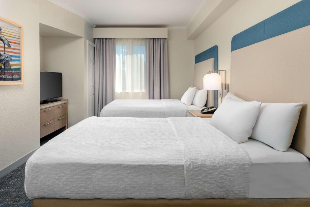 a hotel room with two beds and a television at Homewood Suites by Hilton Bonita Springs, FL in Bonita Springs