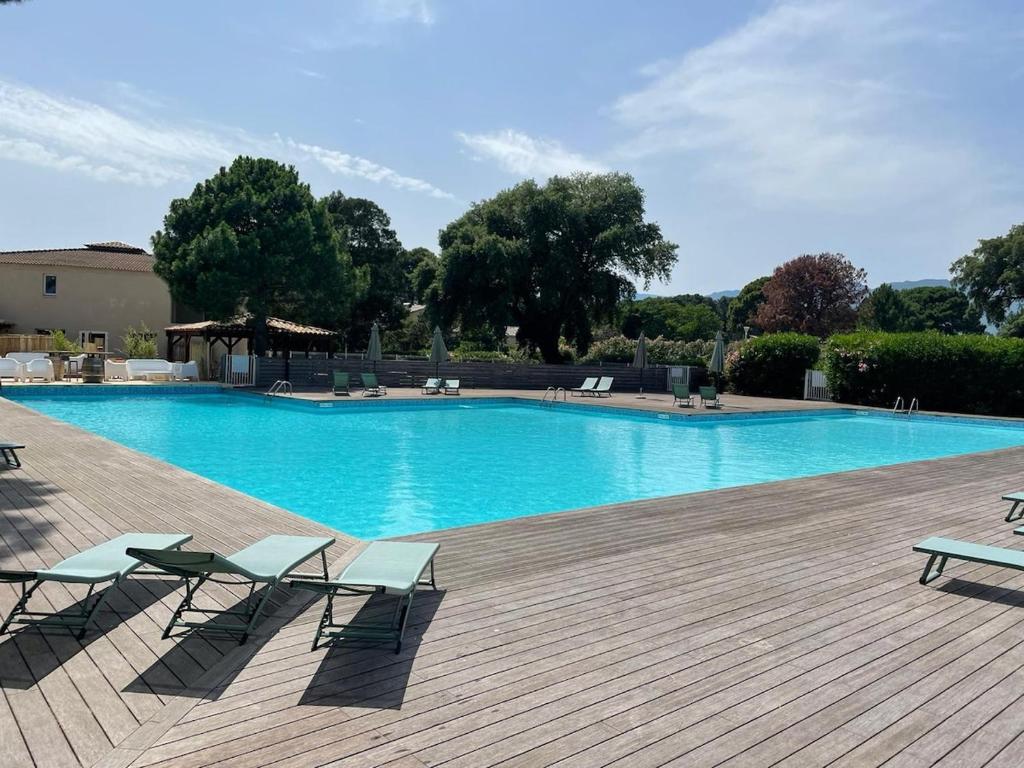 une grande piscine avec des chaises et une terrasse dans l'établissement Studio 47 Cala Rossa Porto Vecchio, à Lecci
