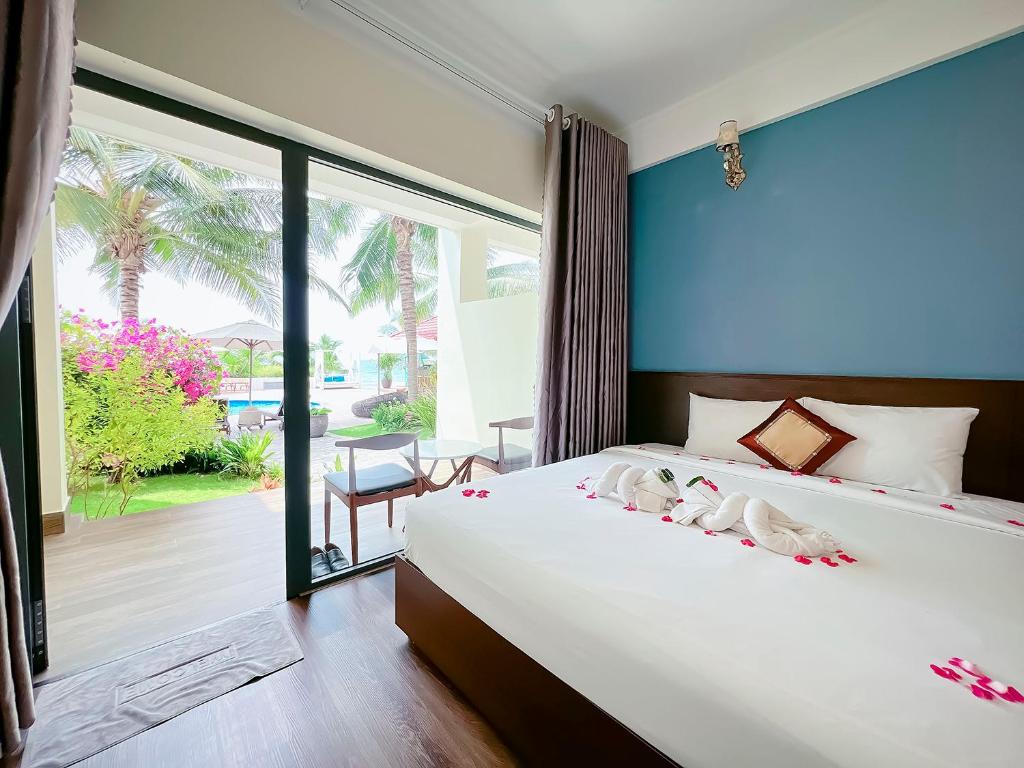 a bedroom with a large bed with two birds on it at Hon Rom 2 Resort in Mui Ne
