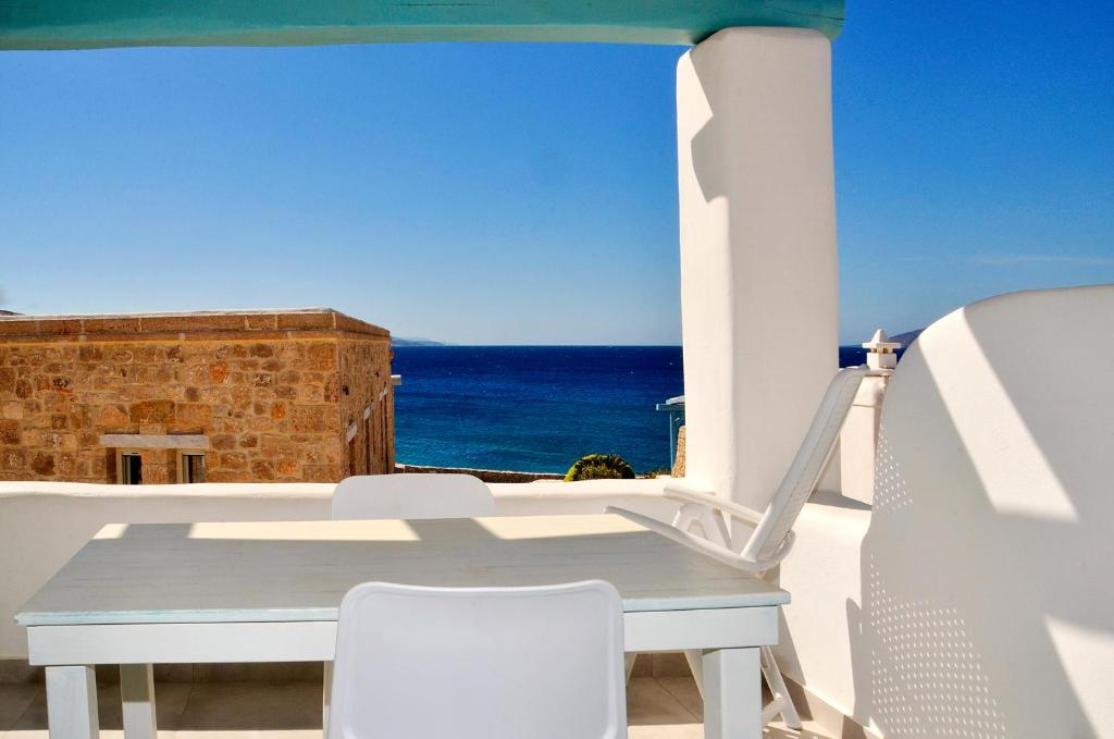 a table and chairs on a balcony with the ocean at Sohoro in Koufonisia