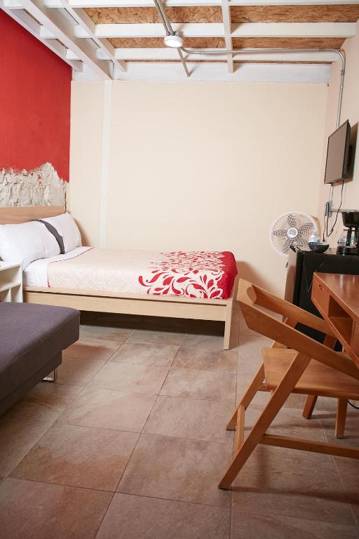 a bedroom with a bed and a chair in a room at Kali Oaxaca Hostel in Oaxaca City