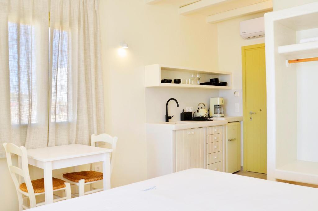 a bedroom with a bed and a desk and a table at Sohoro in Koufonisia