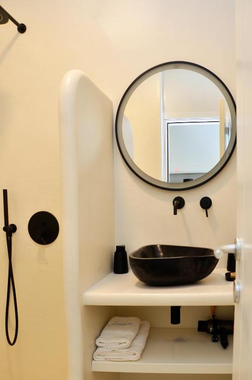 a bathroom with a sink and a mirror on a shelf at Sohoro in Koufonisia