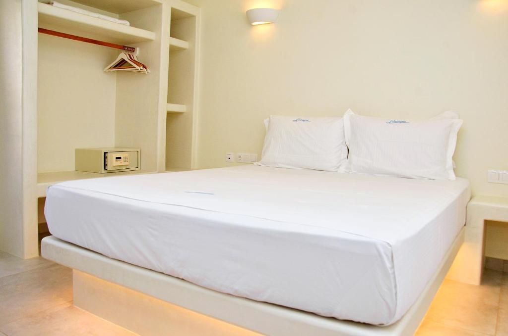 a large white bed with white pillows in a room at Sohoro in Koufonisia