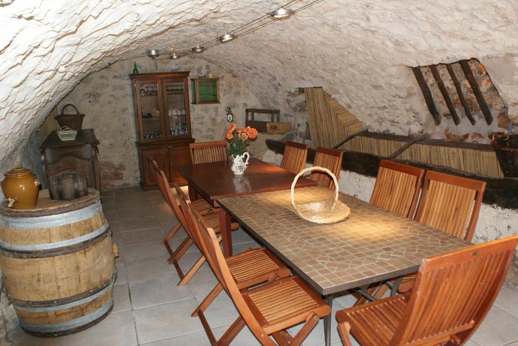 - une salle à manger avec une table, des chaises et un tonneau dans l'établissement Accommodation in a farmhouse with breathtaking views, à Brignoles