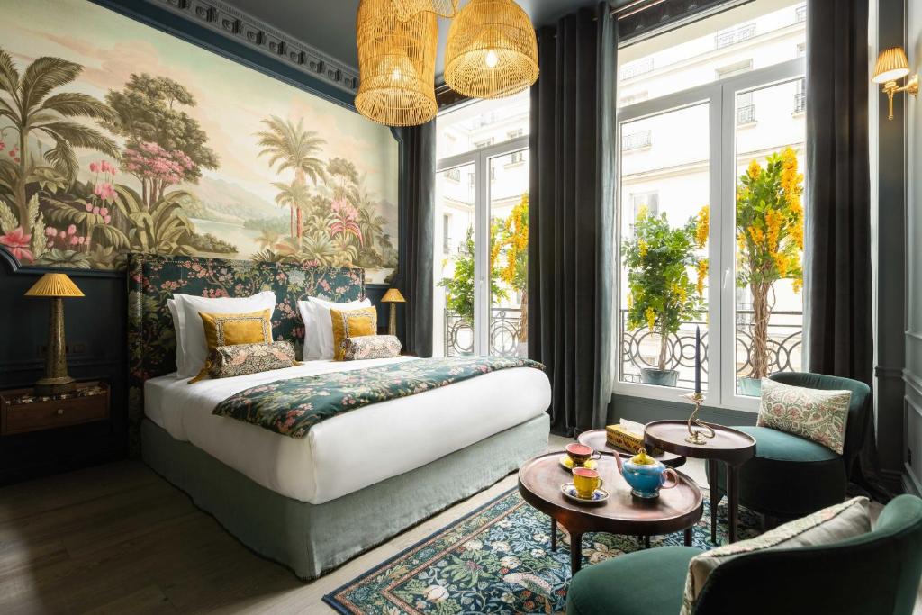 une chambre avec un lit et une grande fenêtre dans l'établissement The Grand Champs Elysées, à Paris