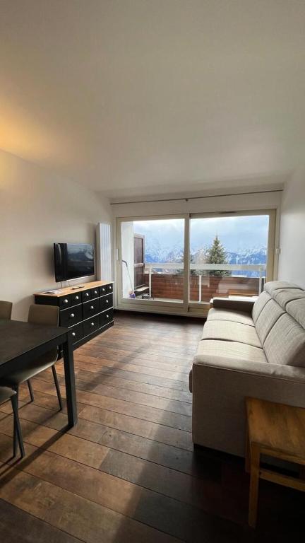 une chambre avec un lit et une télévision et un balcon dans l'établissement Résidence Roche Mantel - APPARTEMENT ALPE D'HUEZ 27m2 ECLOSE EST MAE-0541, à Huez