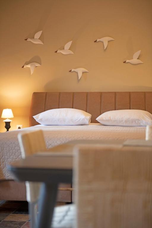 a bedroom with a bed with birds on the wall at Seagulls' House in Evdilos