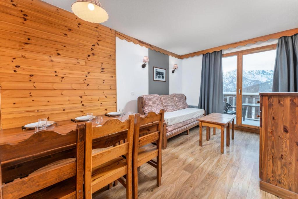 une salle à manger avec une table et un canapé dans l'établissement Résidence Les Hauts De Preclaux - Appartement avec deux chambres aux Orres 1800 MAE-0161, aux Orres