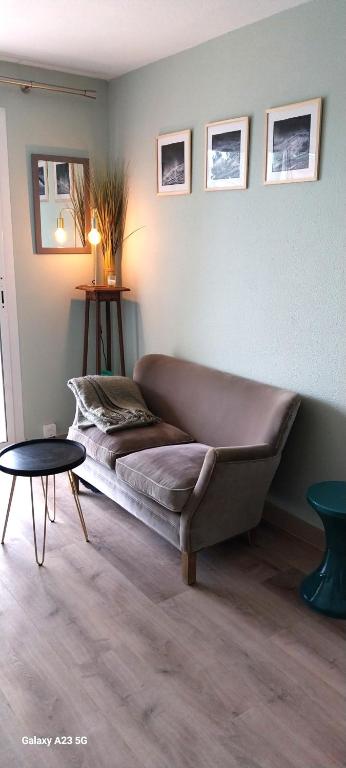 Cette chambre comprend un grand canapé et une table. dans l'établissement joli appartement bord de mer, à Pornic