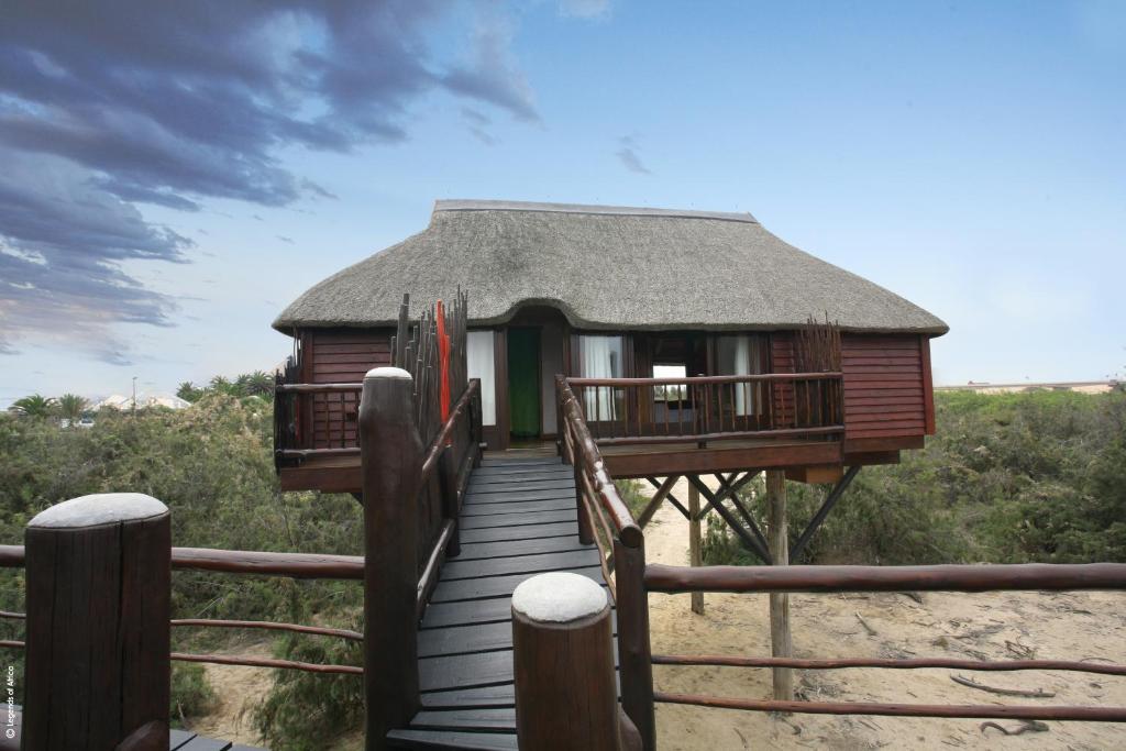 a hut on the beach with a wooden walkway at Stiltz Guest House in Swakopmund