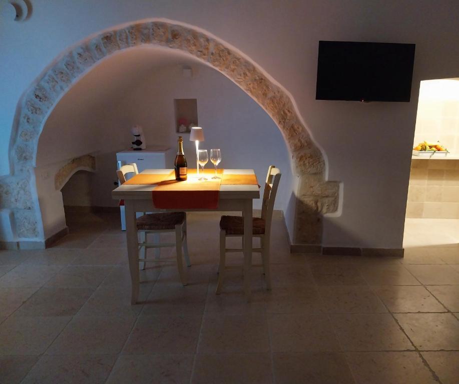 a dining room with a table with two wine glasses at Casa Antonietta - Ostuni Centro in Ostuni