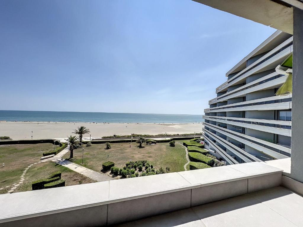 une vue sur la plage depuis le balcon d'un immeuble dans l'établissement Appartement vue mer, clim, wifi et parking - 4BEAU418, à Canet