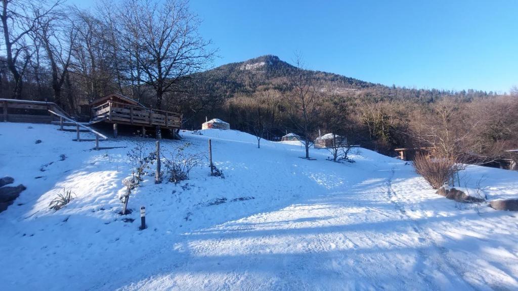 a snow covered field with a mountain in the background at Yourtes Olachat proche Annecy in Faverges