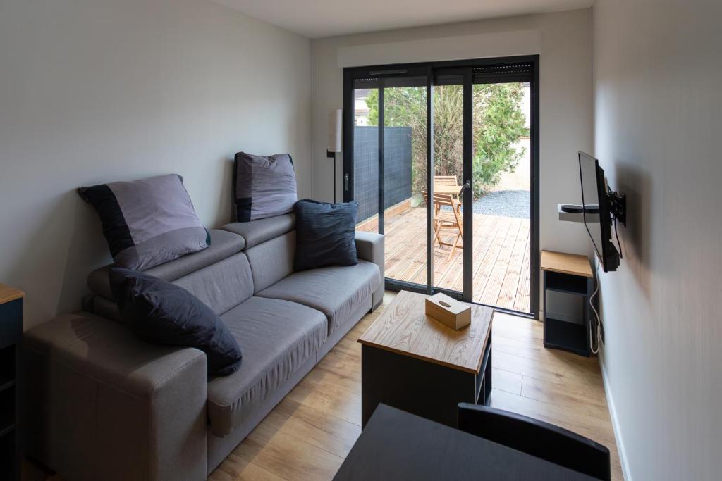 a living room with a couch and a tv at Chez LilYves - Studio avec terrasse privée in Bouray-sur-Juine