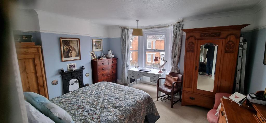 a bedroom with a bed and a dresser and a window at Quirky Victorian three bedroom terraced house in Eastleigh