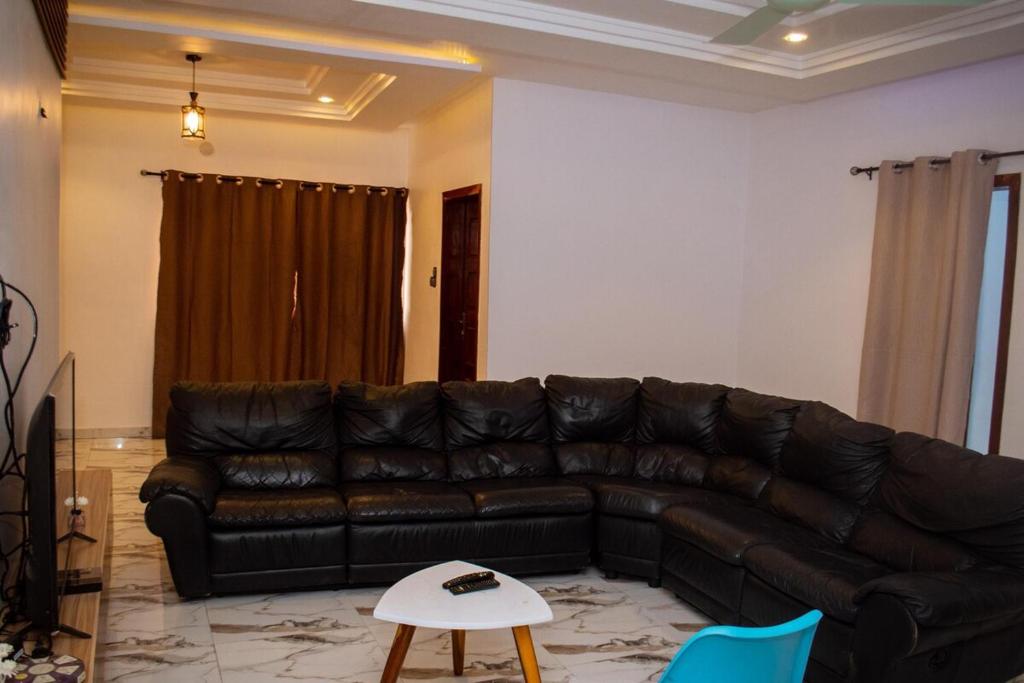 a living room with a leather couch and a table at La Marina 2 in Cotonou