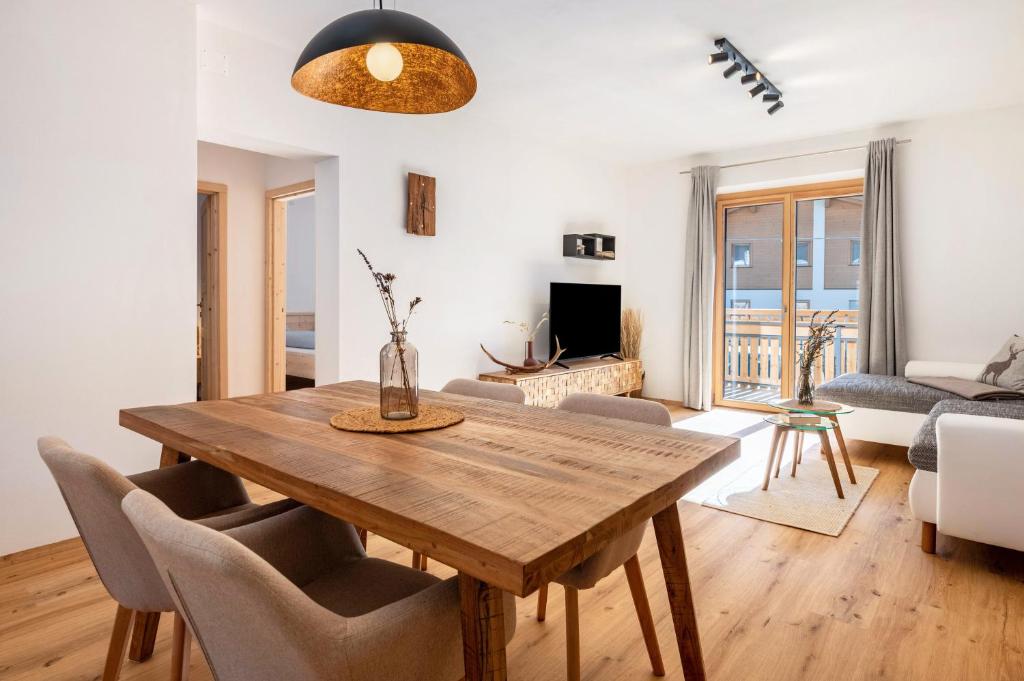 a living room with a wooden table and chairs at Jan's Apartment am See in Pracupola