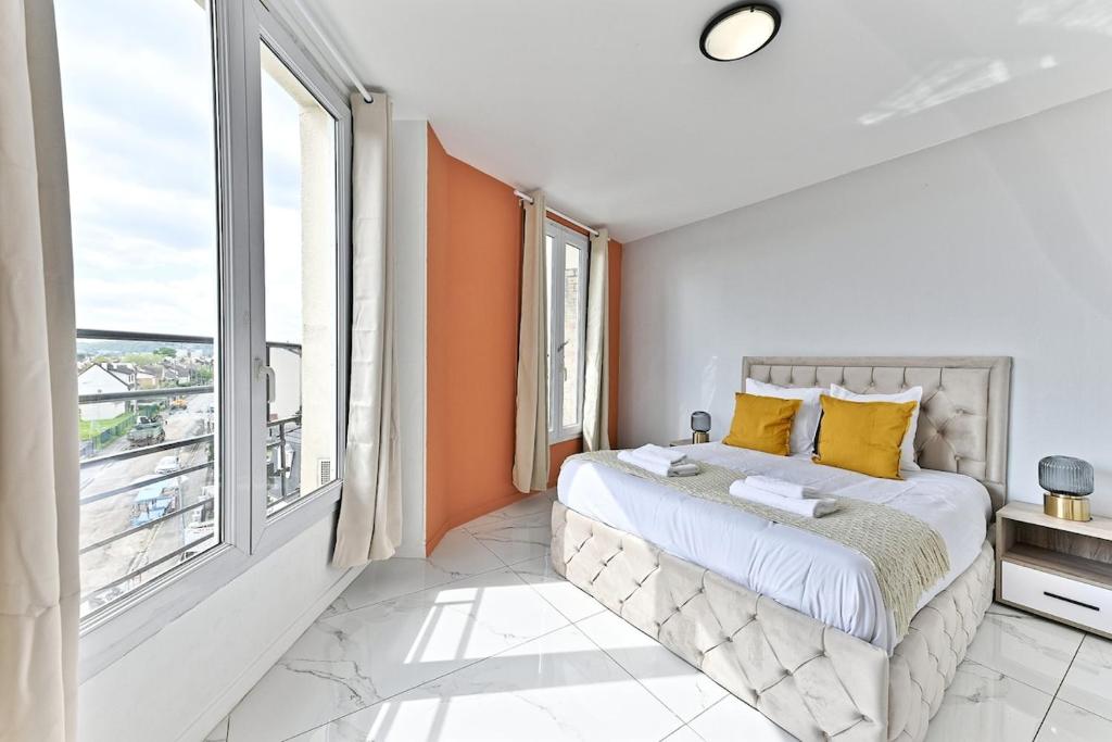 une chambre avec un lit et une grande fenêtre dans l'établissement Appartement paisible en banlieue parisienne - III, à Gagny