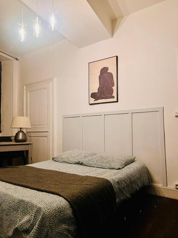 une chambre avec un lit et un tableau au mur dans l'établissement 2- Le chêne bleu, à Poitiers