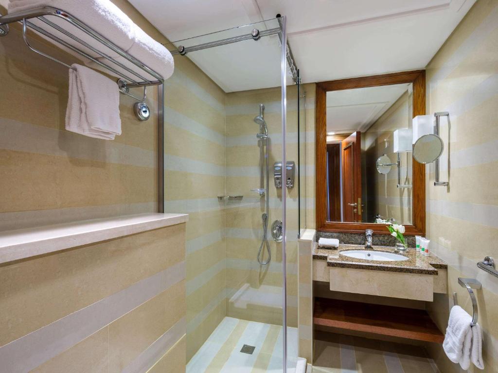 a bathroom with a shower and a sink at Swissotel Al Maqam Makkah in Mecca