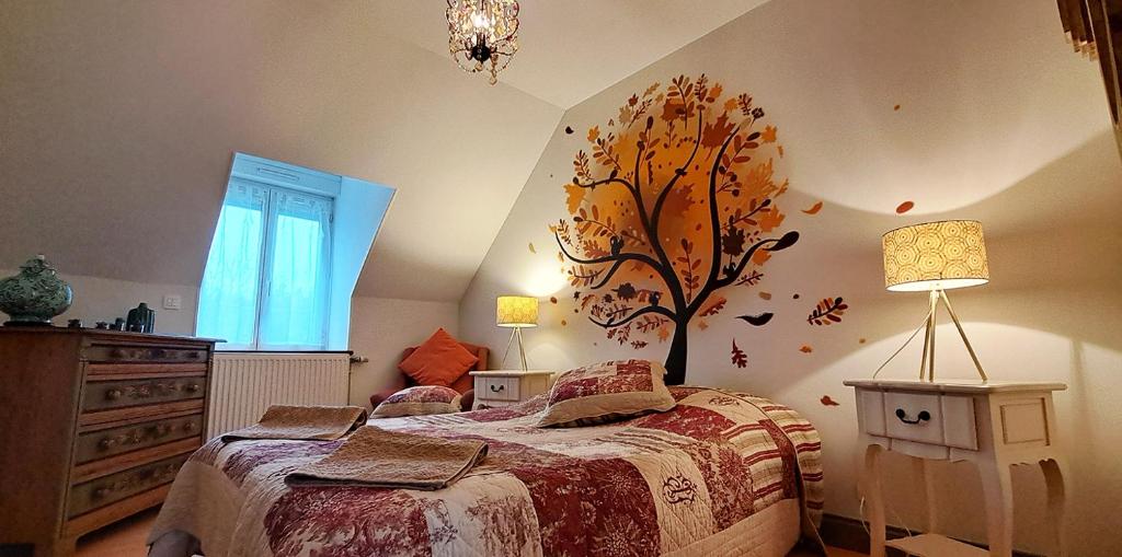 a bedroom with a bed with a tree on the wall at Domaine de montboulon in Saint-Georges-sur-Baulche