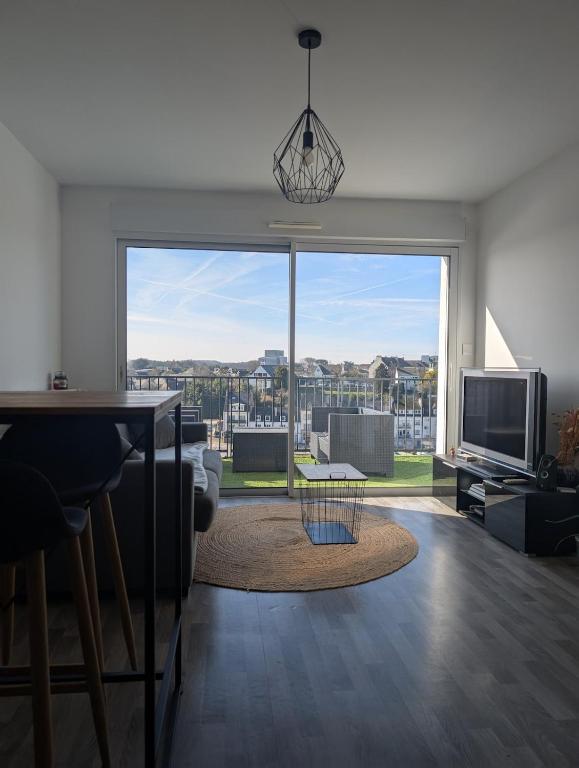 un salon avec une grande fenêtre avec vue dans l'établissement Le Panoramique, à Hennebont