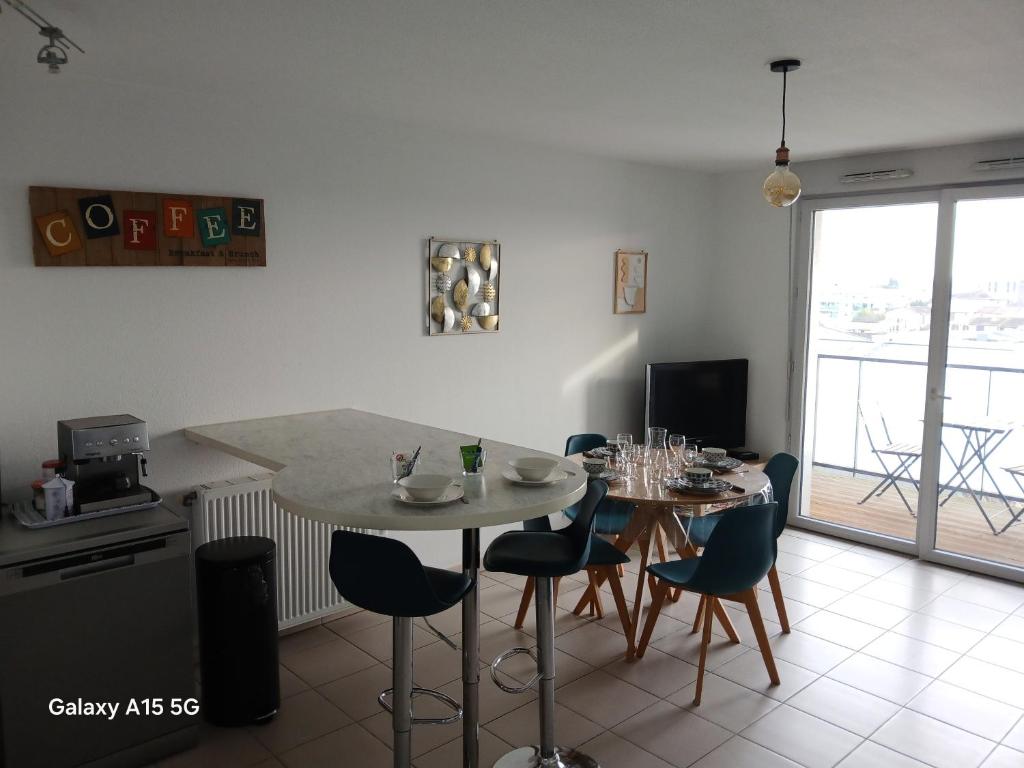 une cuisine avec une table et des chaises dans une pièce dans l'établissement Spacieux T3 Balcon Parking Privé, à Toulouse