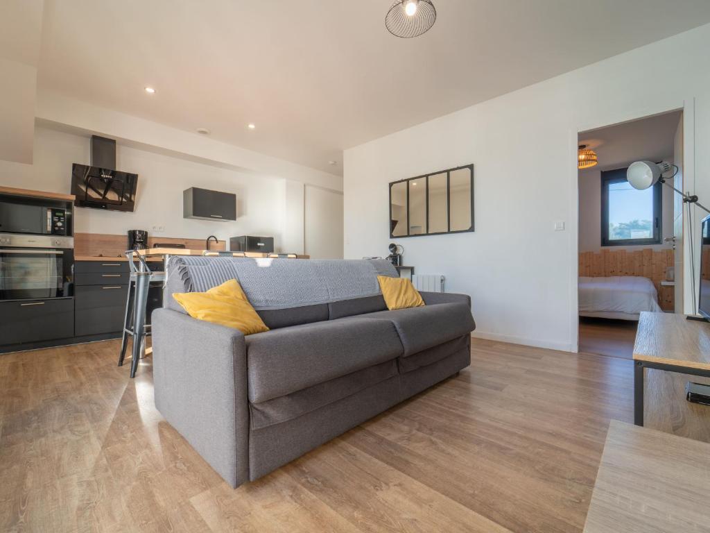 un salon avec un canapé et une cuisine dans l'établissement Charmant appartement à 200m de l'océan avec terrasse et parking - FR-1-50-157, à Mimizan
