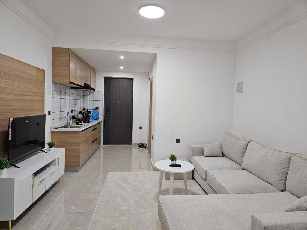 a living room with a couch and a kitchen at A cozy studio apartment in Ruaka