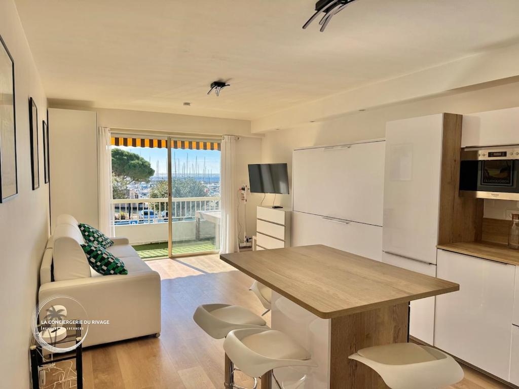 une cuisine et un salon avec une table et un canapé dans l'établissement Studio rénové face à la mer - Port de Carqueiranne, à Carqueiranne