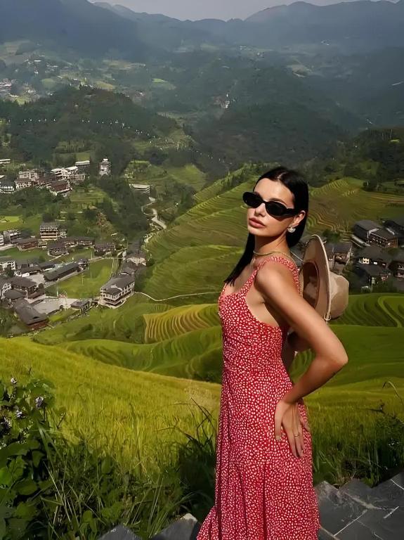 和平乡幸福住酒店的一位身穿红裙的女子站在山上