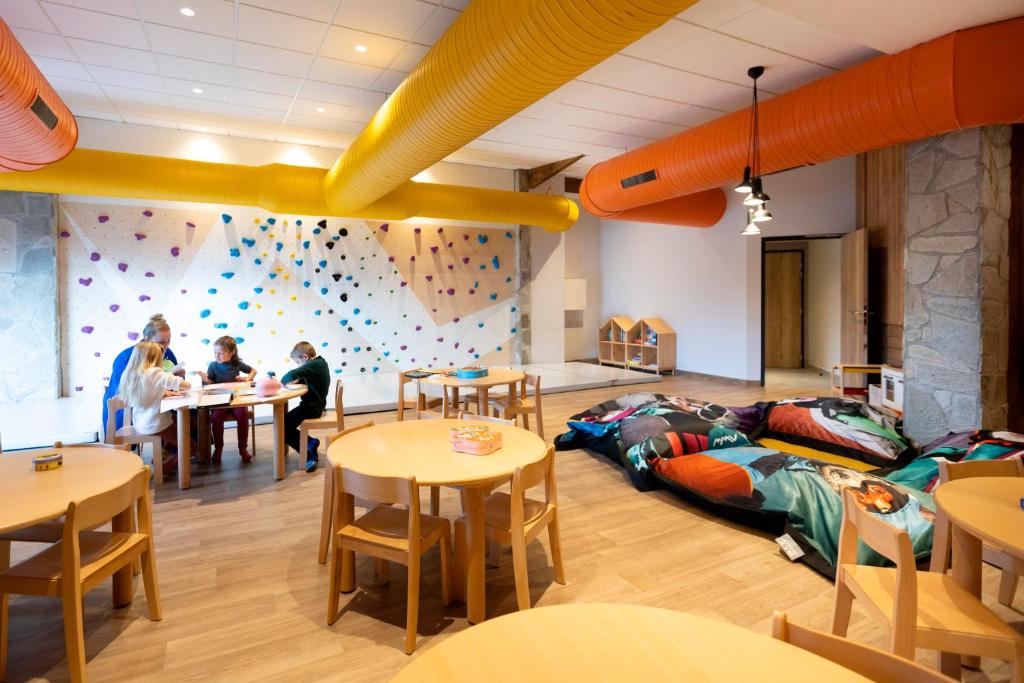 a room with a climbing gym with people sitting at tables at Hôtel Club mmv Les Bergers **** in L'Alpe-d'Huez