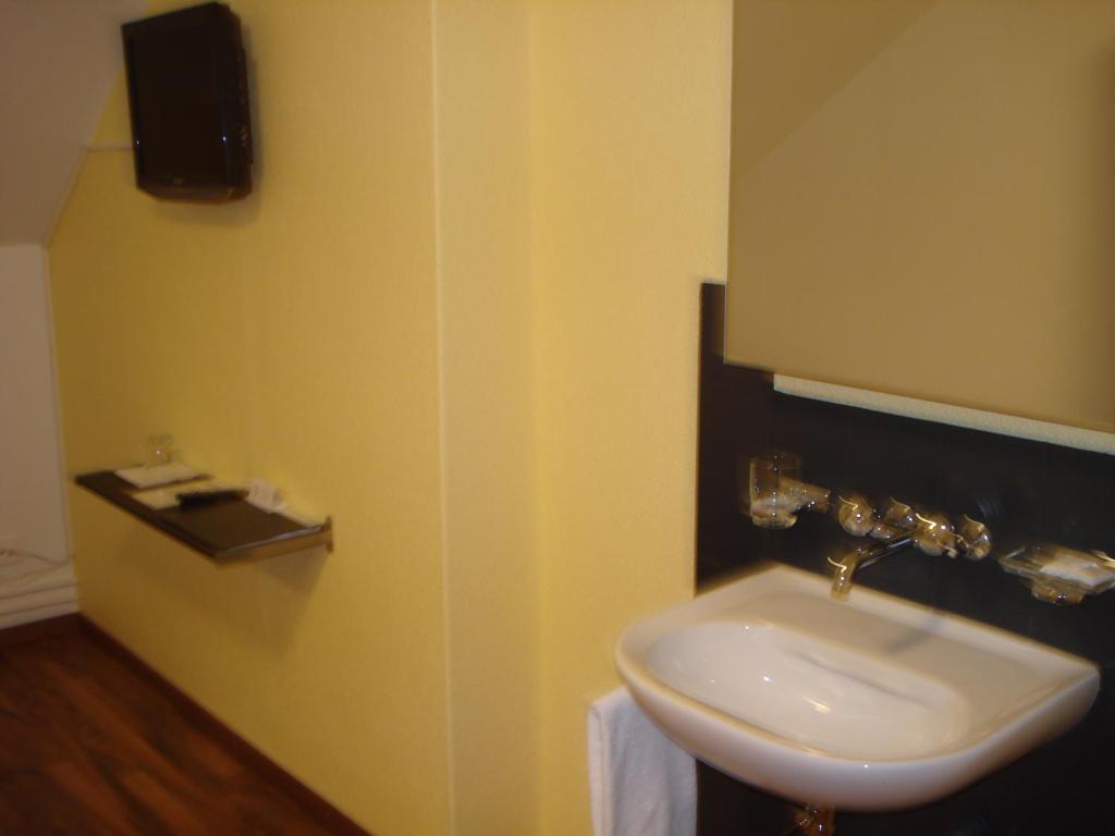 a bathroom with a white sink and a mirror at Hotel Gregory in Zürich